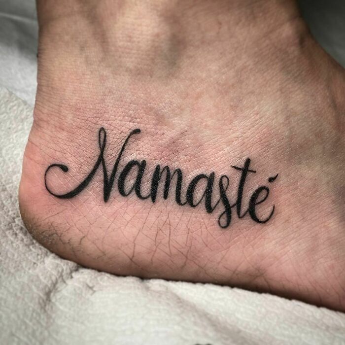 "Word tattoo 'Namaste' inked creatively on skin for inspiration."