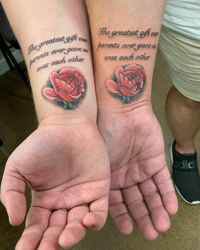 Brother and sister tattoos with red roses and a quote celebrating their bond on each wrist.