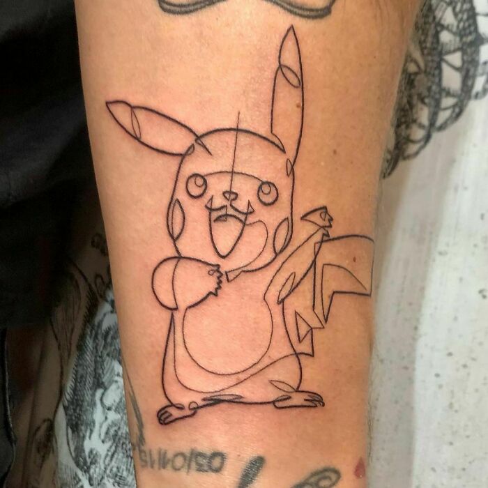 Fine-line single-line tattoo of Pikachu on forearm, showcasing minimalist design and artistic precision.