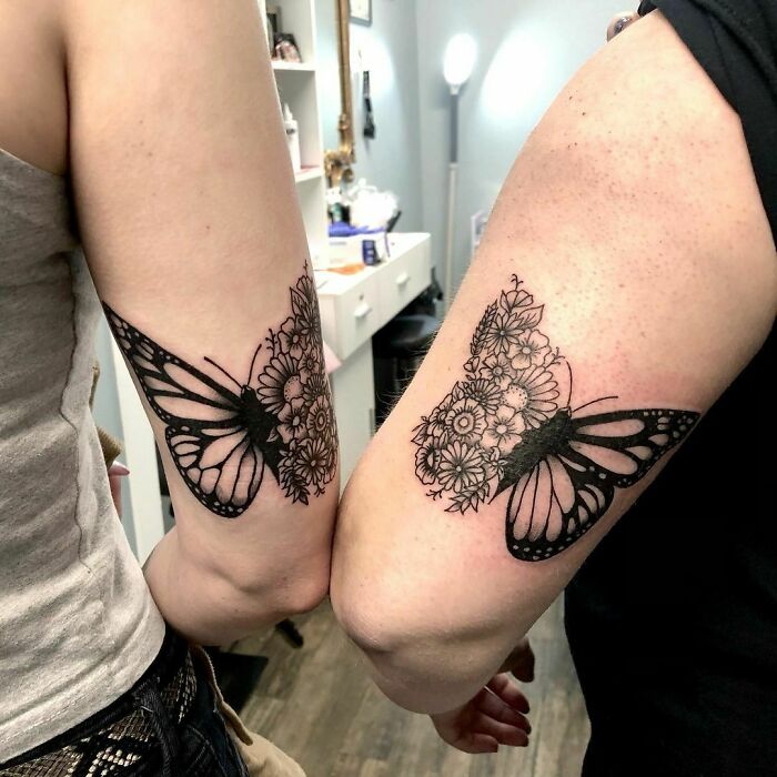 Butterfly BFF tattoos on forearms, with floral designs, showcasing friendship and matching ink ideas.
