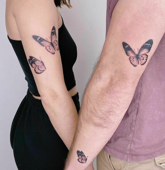 Brother and sister showing matching butterfly tattoos on their arms.