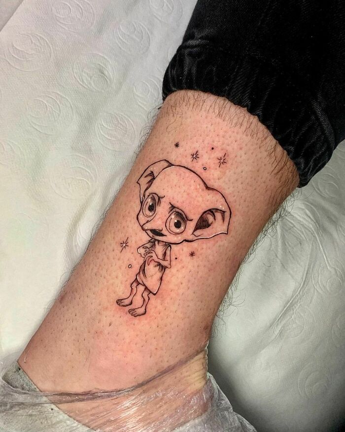 Dobby tattoo on ankle with stars, showcasing Harry Potter fan art.