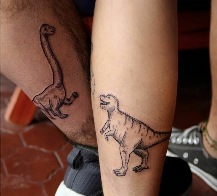 Brother and sister dinosaur tattoos on legs, symbolizing their bond.