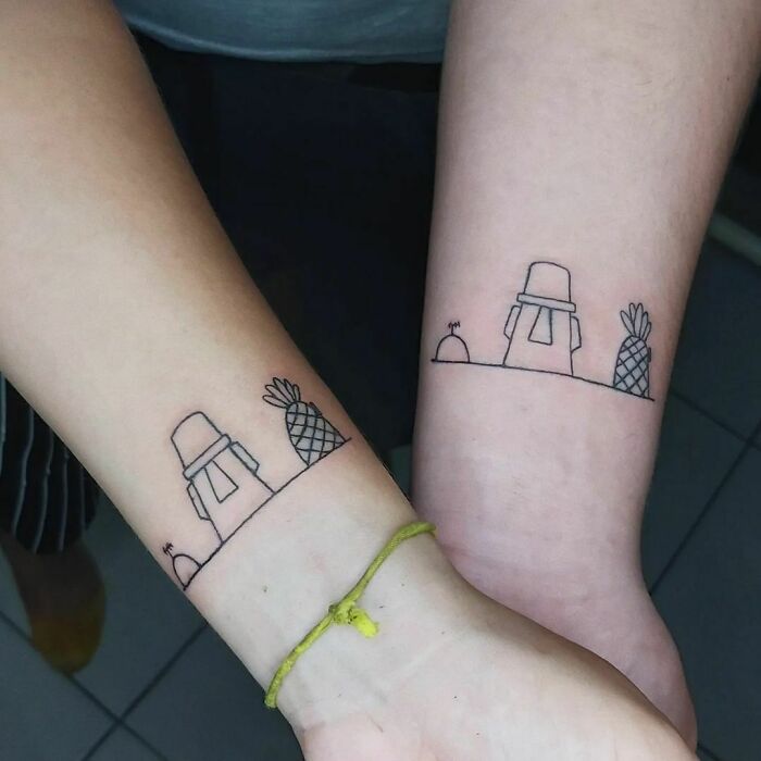 Brother and sister matching tattoos of simple line art featuring pineapples and towers on forearms.