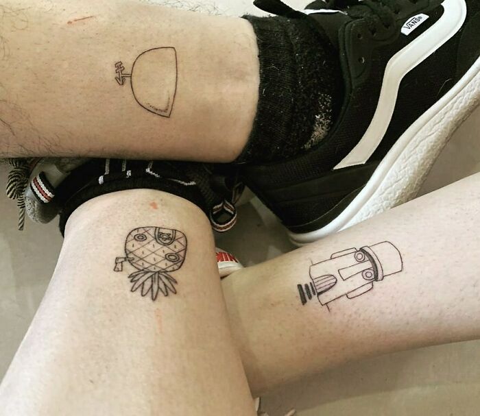 Small, simple brother and sister tattoos on legs, featuring a taco, pineapple, and robot design.