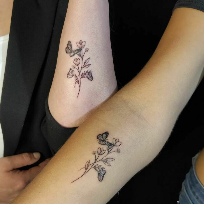 Brother and sister tattoo featuring matching floral and butterfly designs on arms.