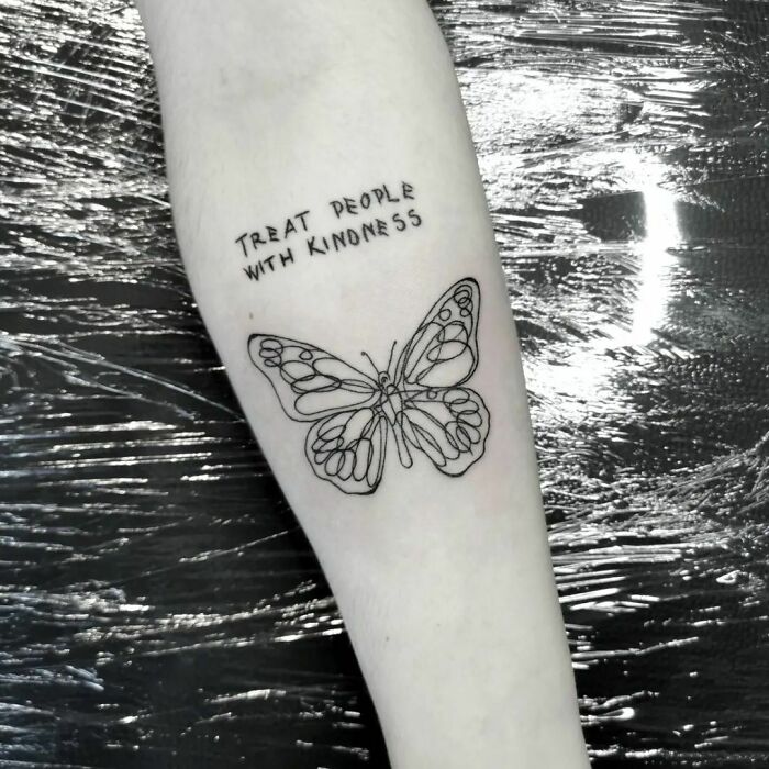 Butterfly and quote tattoo on forearm for creative word tattoo inspiration.