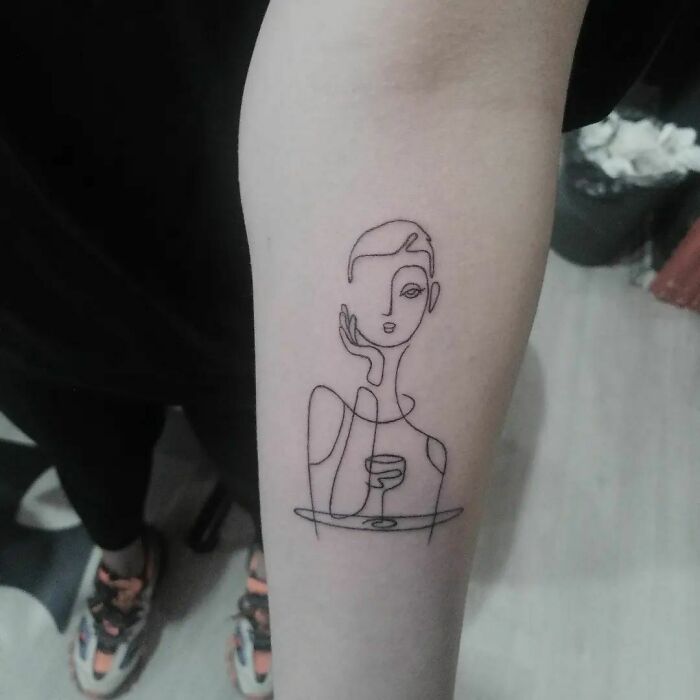 Minimal line tattoo of a woman with a wine glass on forearm, perfect for minimalism enthusiasts.