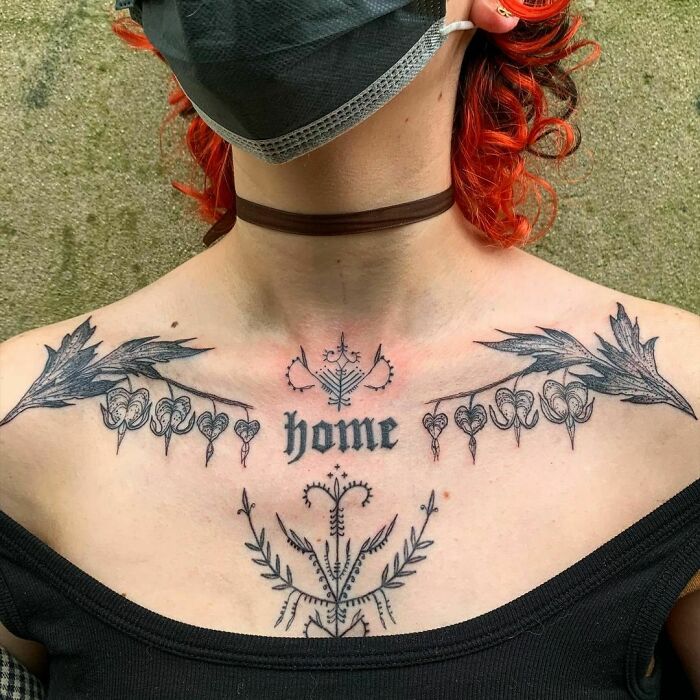 Chest word tattoo idea with floral designs surrounding the word "home."