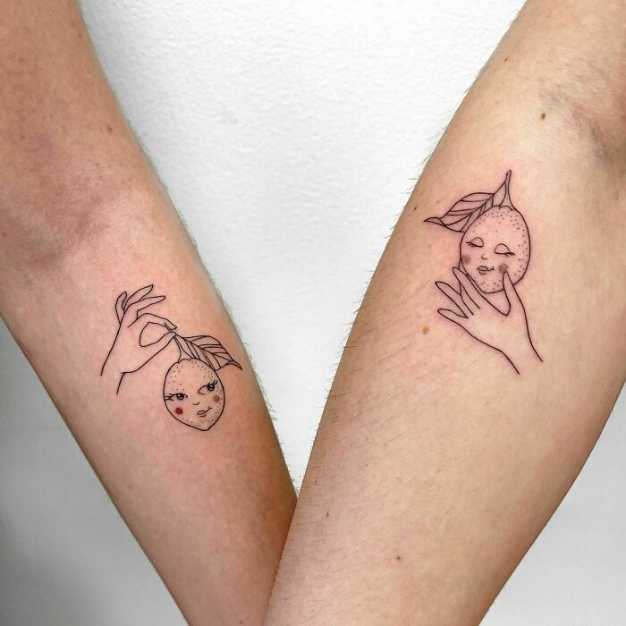 Matching BFF tattoos of lemons with faces and hands on two arms.