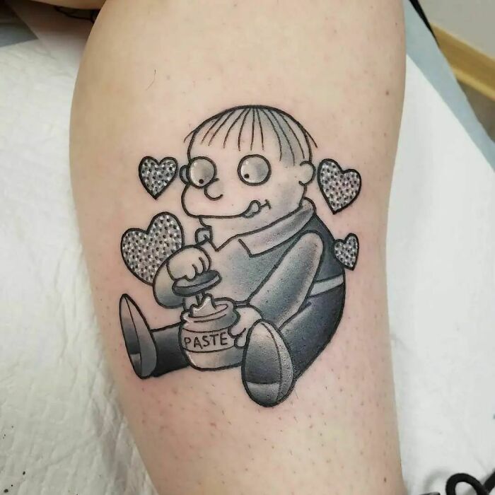 Cartoon tattoo of a child with paste jar, surrounded by hearts, reminiscent of childhood favorites.