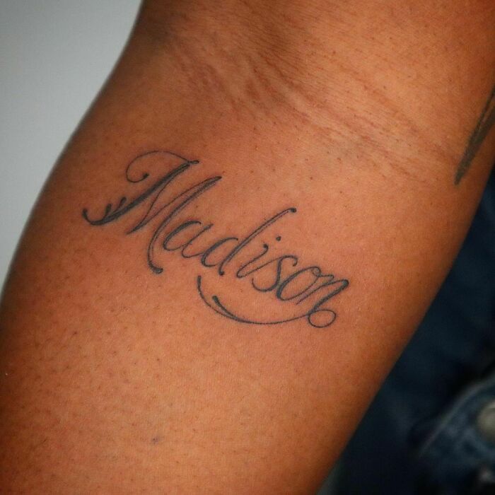 Tattoo of the word "Madison" in elegant script on an arm, showcasing creative word tattoos.