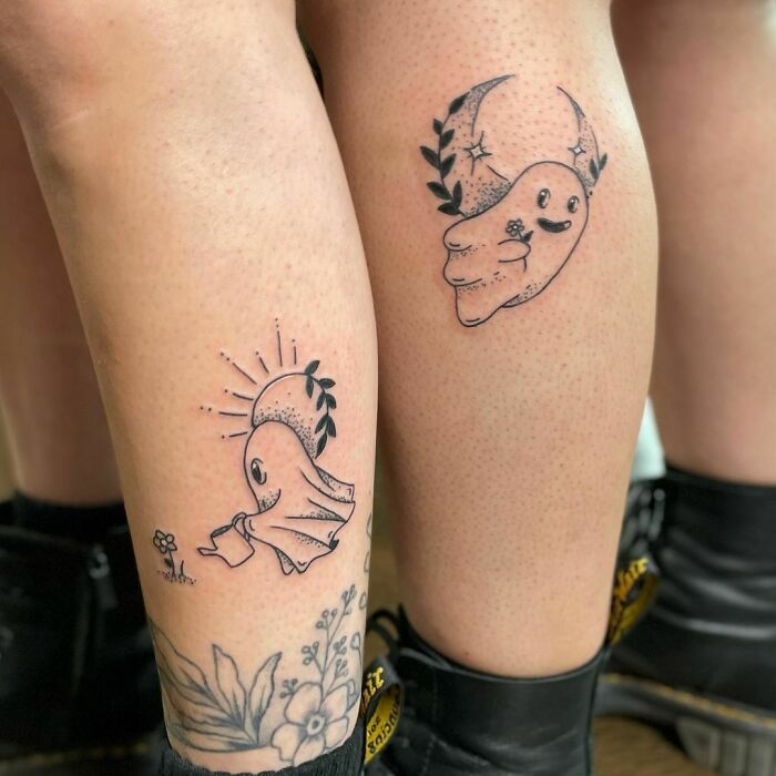 Ghost-themed best friend tattoos on legs featuring cute designs with stars and floral accents.