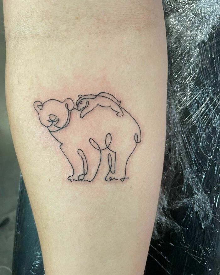 Minimalism line tattoo featuring a playful bear and seal design on forearm.