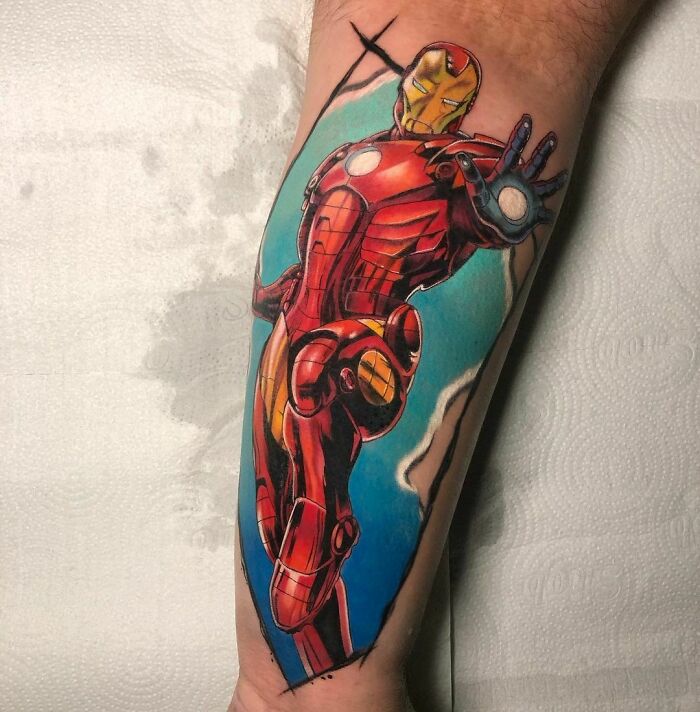 Vibrant tattoo of Iron Man on arm, showcasing Marvel artistry with dynamic colors.
