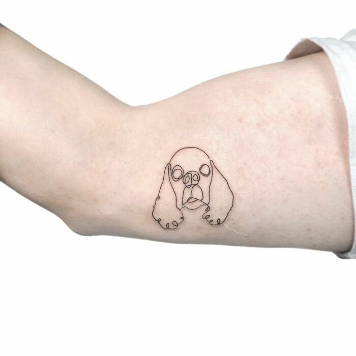 Minimalism line tattoo of a dog on forearm, showcasing unique and simple design.