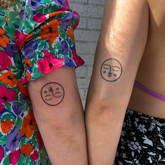 Matching BFF tattoos of abstract faces on two people's arms, symbolizing friendship and unity.