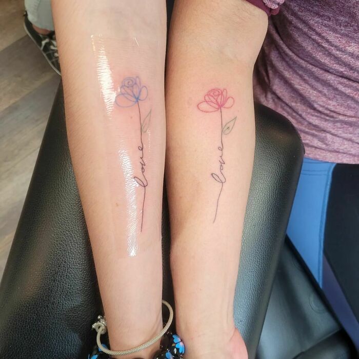 Minimalist line tattoos with flowers and the word "love" on forearms, showcasing unique design ideas for minimalism enthusiasts.