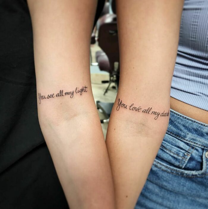 Matching best friend tattoos on forearms with quotes 'You see all my light' and 'You love all my dark'.