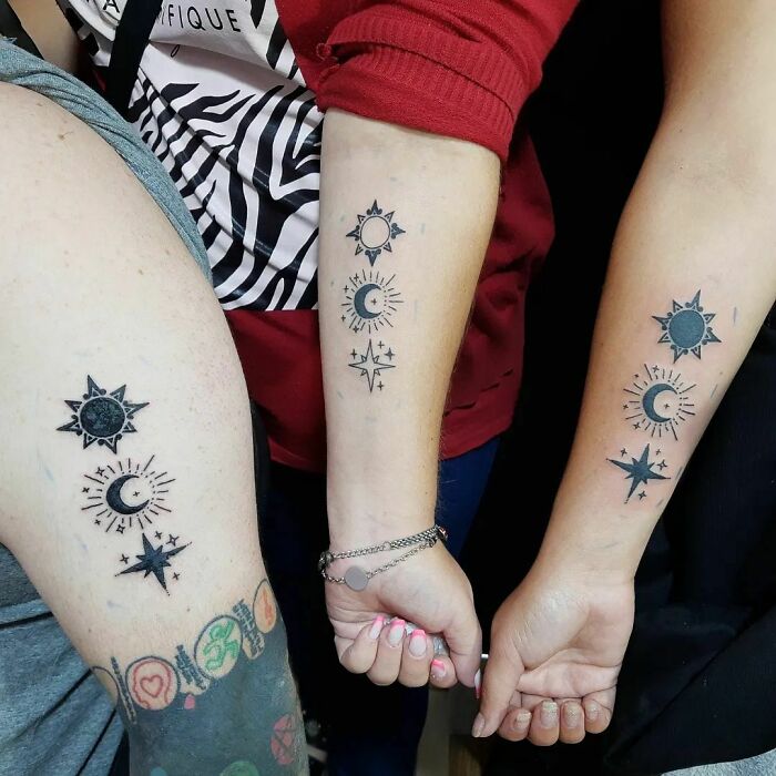 Brother and sister tattoos of matching sun, moon, and star designs on three different arms.