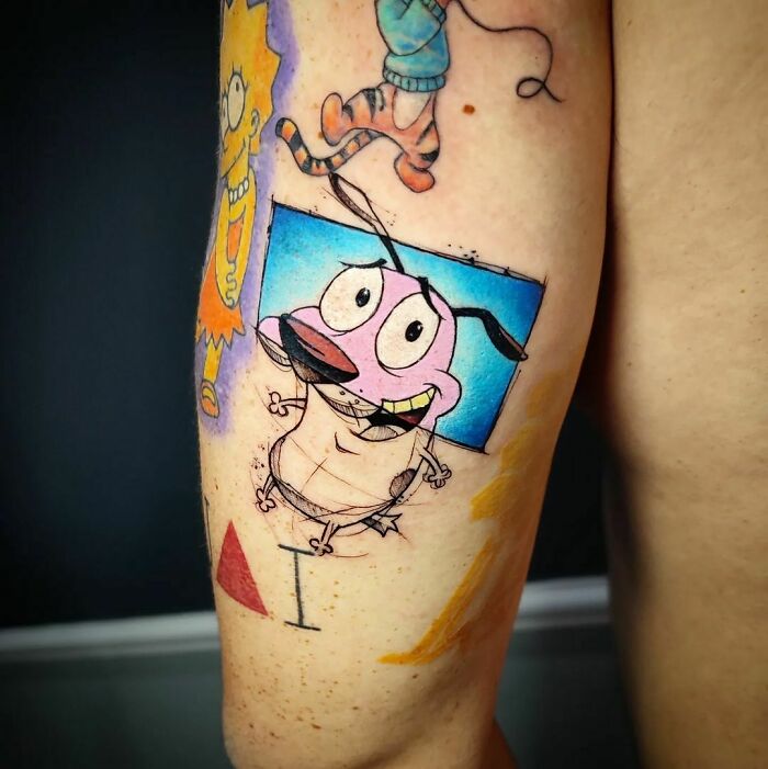 Cartoon tattoos featuring classic character Courage The Cowardly Dog on an arm, illustrating vibrant and nostalgic designs.