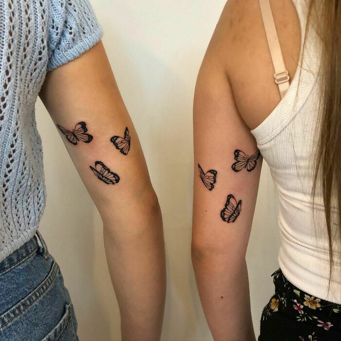 Matching butterfly best friend tattoos on two women's arms, symbolizing friendship and unity.
