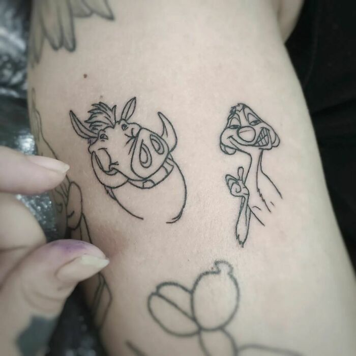 Cartoon tattoo of animated characters in black ink, inspired by favorite shows.