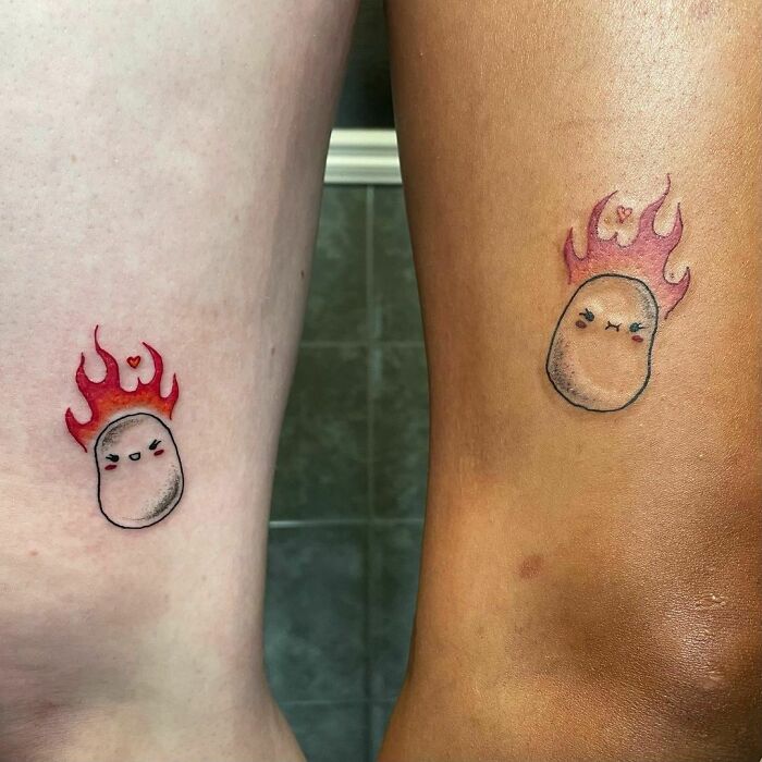 Cute best friend tattoos with matching flame designs on two people's arms.