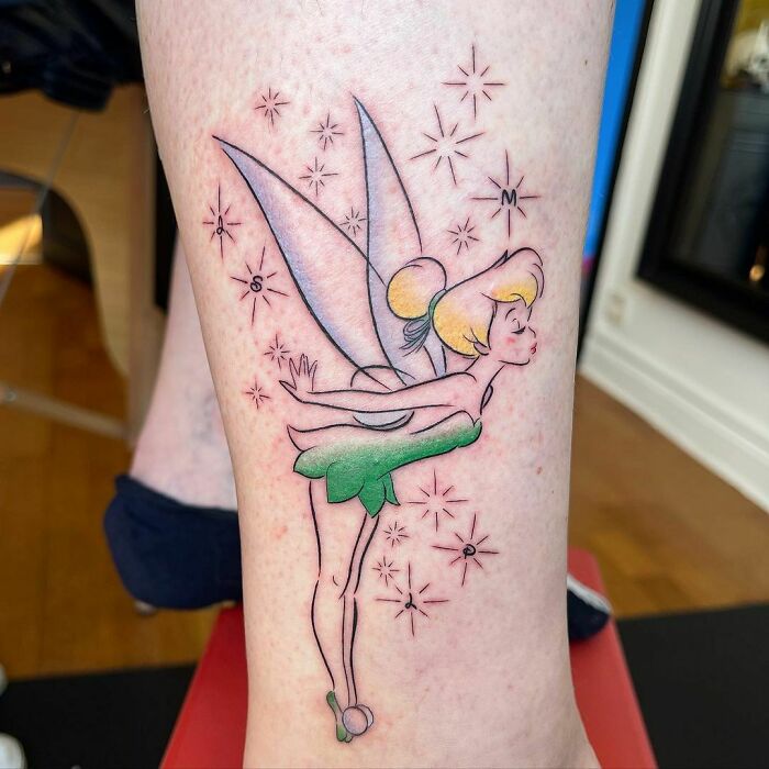 A fairy-themed watercolor tattoo featuring vibrant colors and ethereal design on a person's leg.