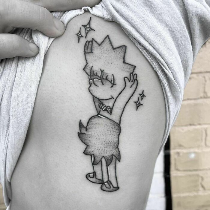 Cartoon tattoo of a joyful character with stars, reminiscent of childhood favorites, on an arm.