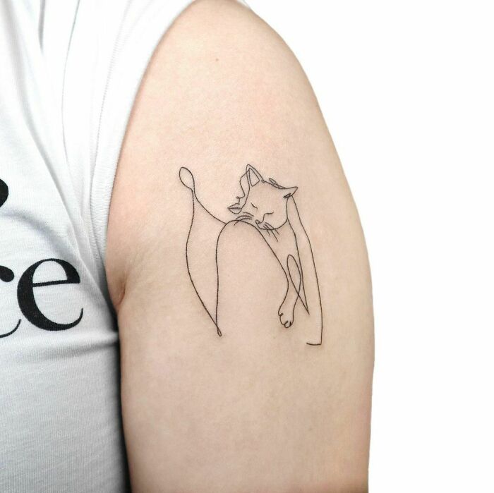 Fine-line single-line cat tattoo on a person's arm, showcasing artistic minimalism.
