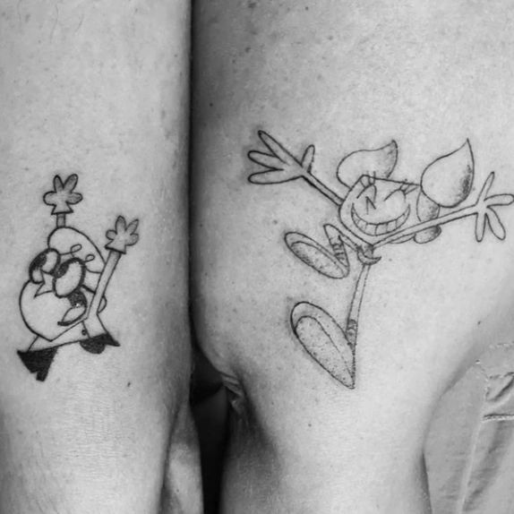 Simple brother and sister tattoos featuring cartoon characters on arms.