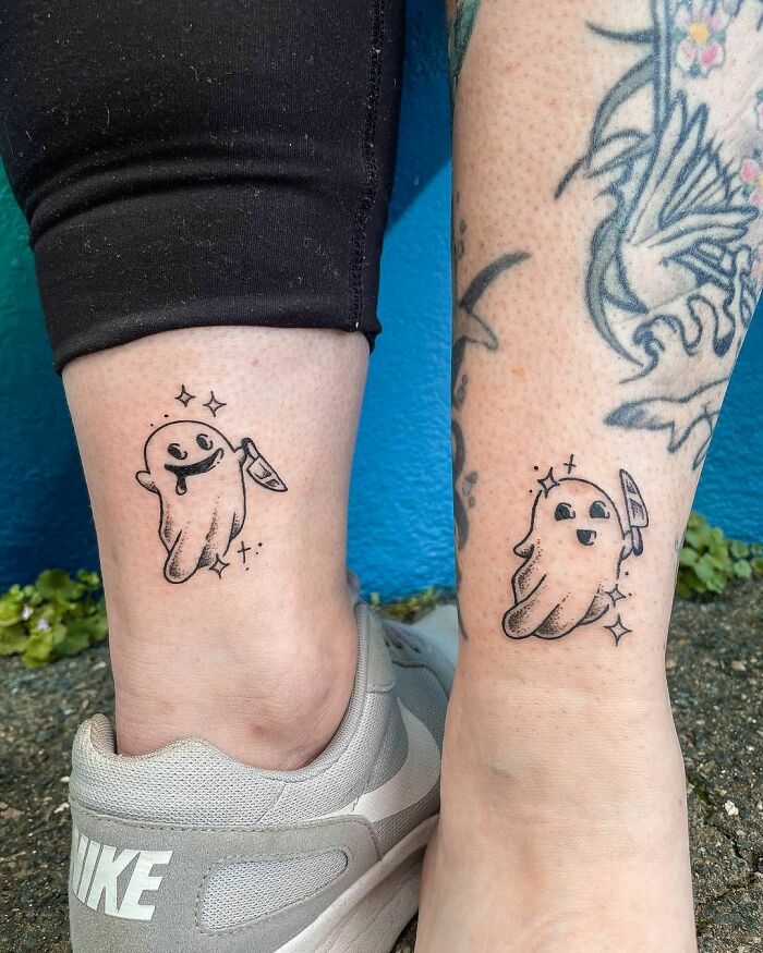 Matching ghost BFF tattoos on ankles with small knives and sparkles, symbolizing friendship and shared adventures.