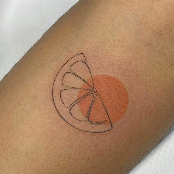 Single-line tattoo of an orange slice with a shaded circle on an arm, showcasing artistic minimalism.