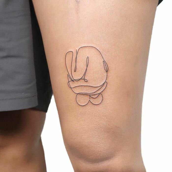 Minimal line tattoo design on a person's thigh, showcasing unique minimalist art style.
