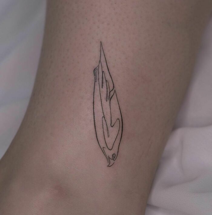 Fine-line single-line tattoo of a stylized feather on skin.