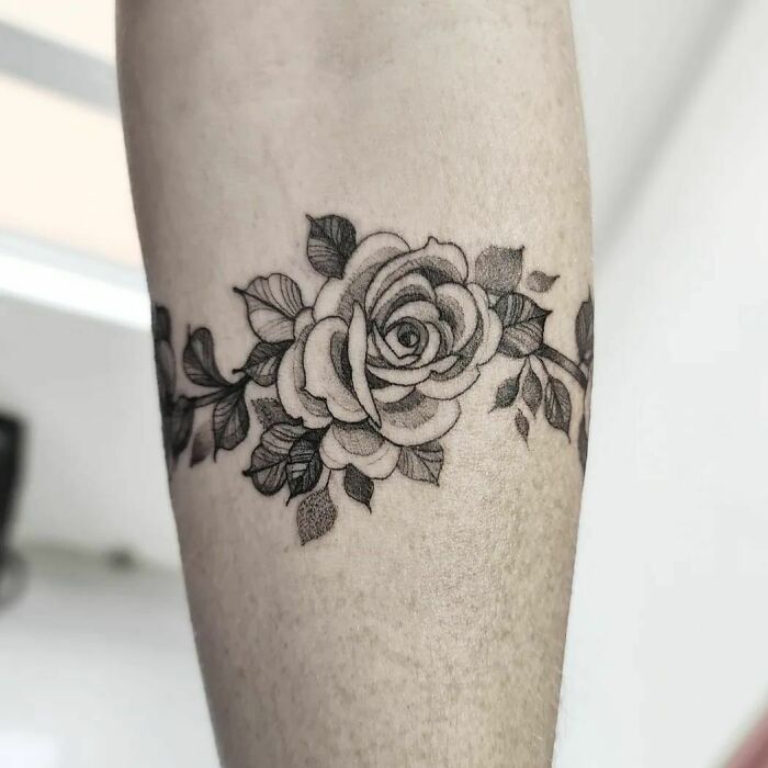 Rose armband tattoo design, featuring detailed floral elements on an arm.