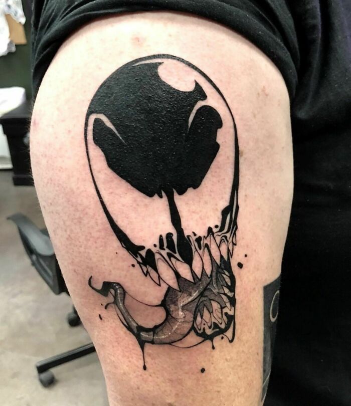 Marvel tattoo of a stylized Venom design in black ink on someone's arm.