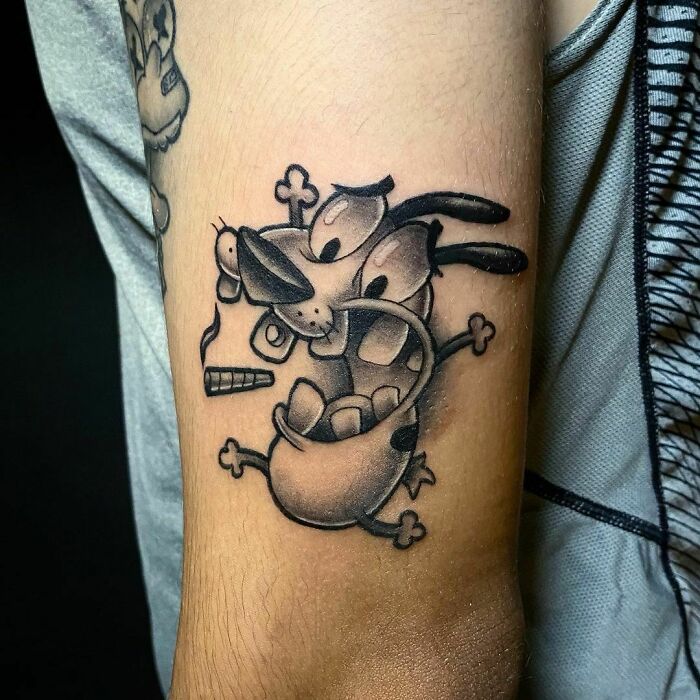 Cartoon tattoo on arm featuring a nostalgic character, showcasing bold black shading and playful expression.