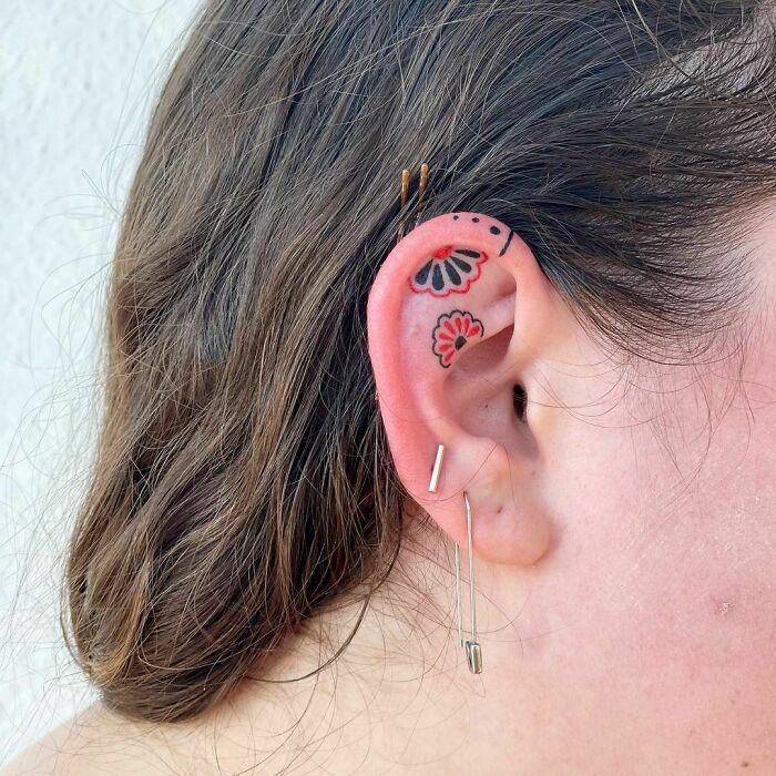 Floral ear tattoo design with bold colors and unique flower patterns.