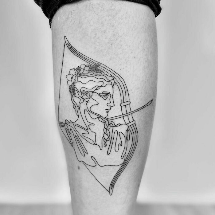 Single-line tattoo of an archer in grayscale on a person's calf.