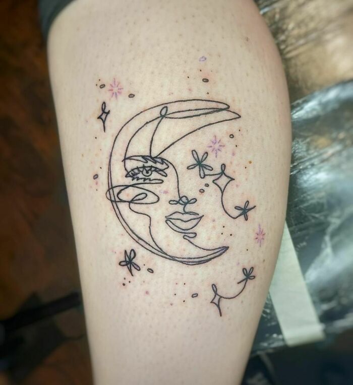 Fine-line tattoo of a crescent moon and stars in single-line style on forearm.