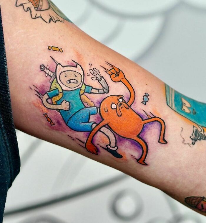 Cartoon tattoo inspired by favorite animated shows featuring two colorful characters in action.
