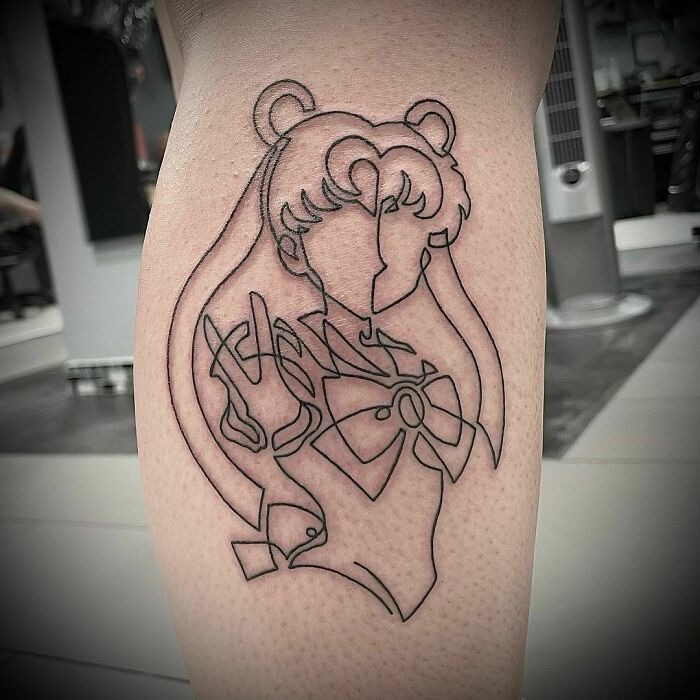 Minimalist line tattoo of a stylized character, showcasing elegant line art design on a person's calf.