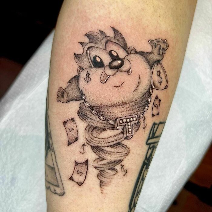 Cartoon tattoo of a whirling character holding money bags, reminiscent of childhood favorites.