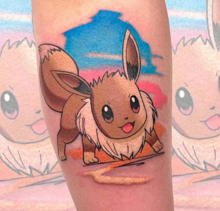Cartoon tattoo of a playful character Eevee with vibrant colors, capturing nostalgic vibes on the forearm.