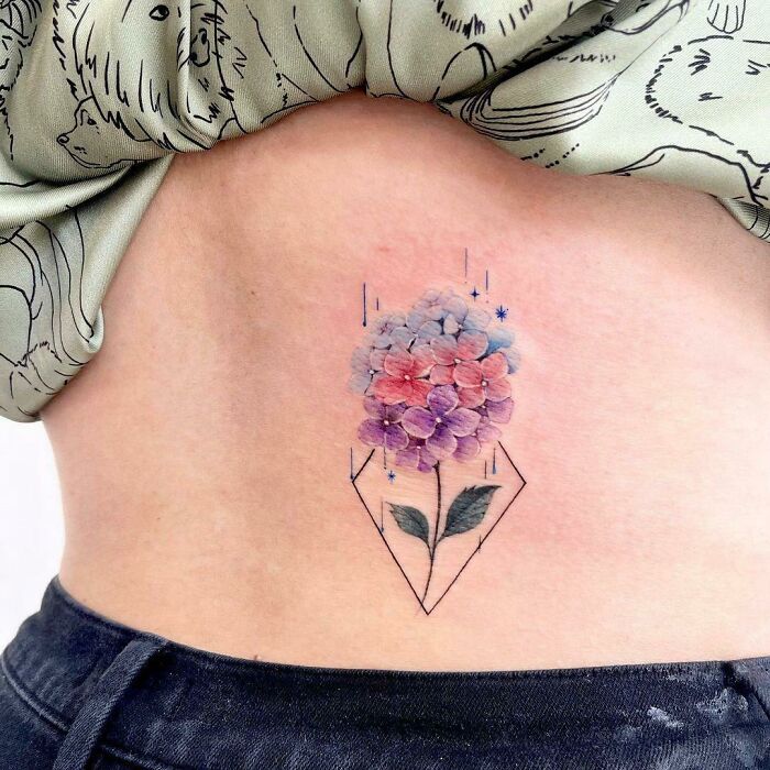 Watercolor tattoo of a pastel floral design on skin, showcasing ethereal art.