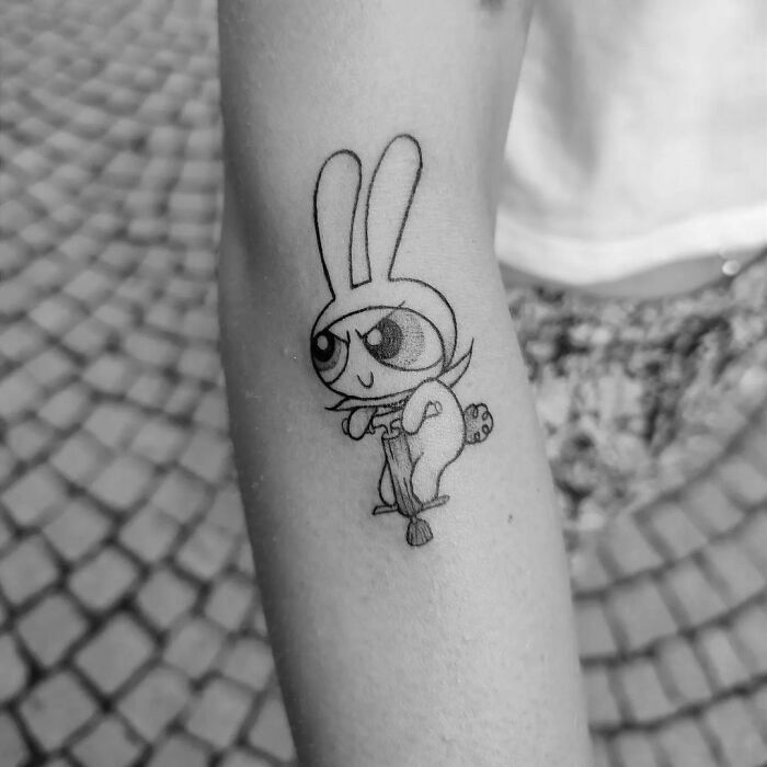 Powerpuff Girls tattoo on arm, featuring a character in bunny costume, evoking cartoon nostalgia.