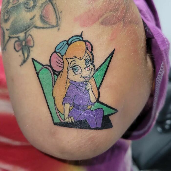 Cartoon tattoo of a classic character with vibrant colors on an arm, featuring detailed 90s nostalgia artwork.