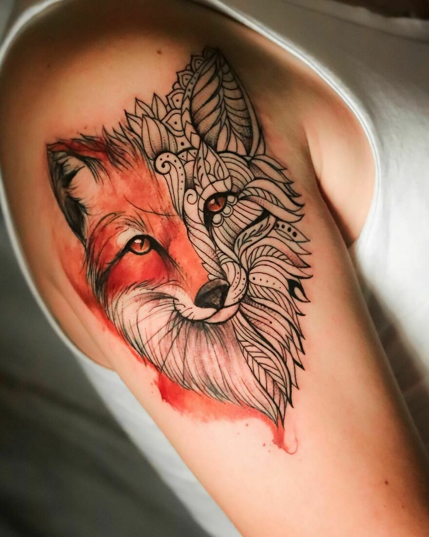 Watercolor tattoo of a fox with geometric patterns on an arm.